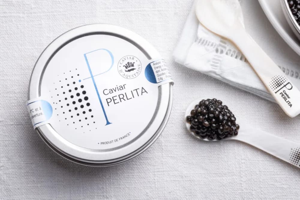 Boîte de Caviar Perlita ouverte, une cuillère de nacre garnie de caviar
