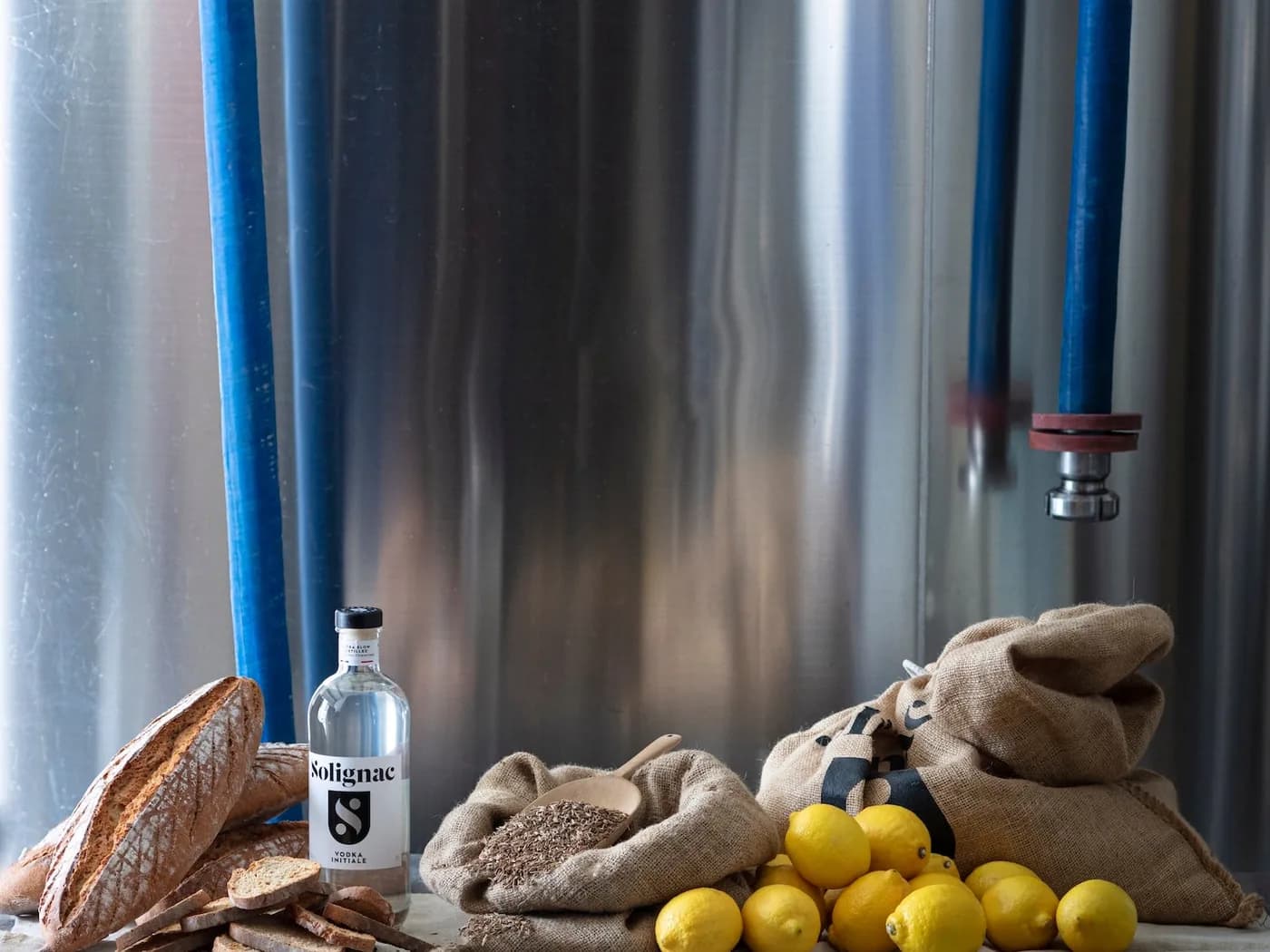 Ingrédients de macération et bouteille Solignac devant une cuve