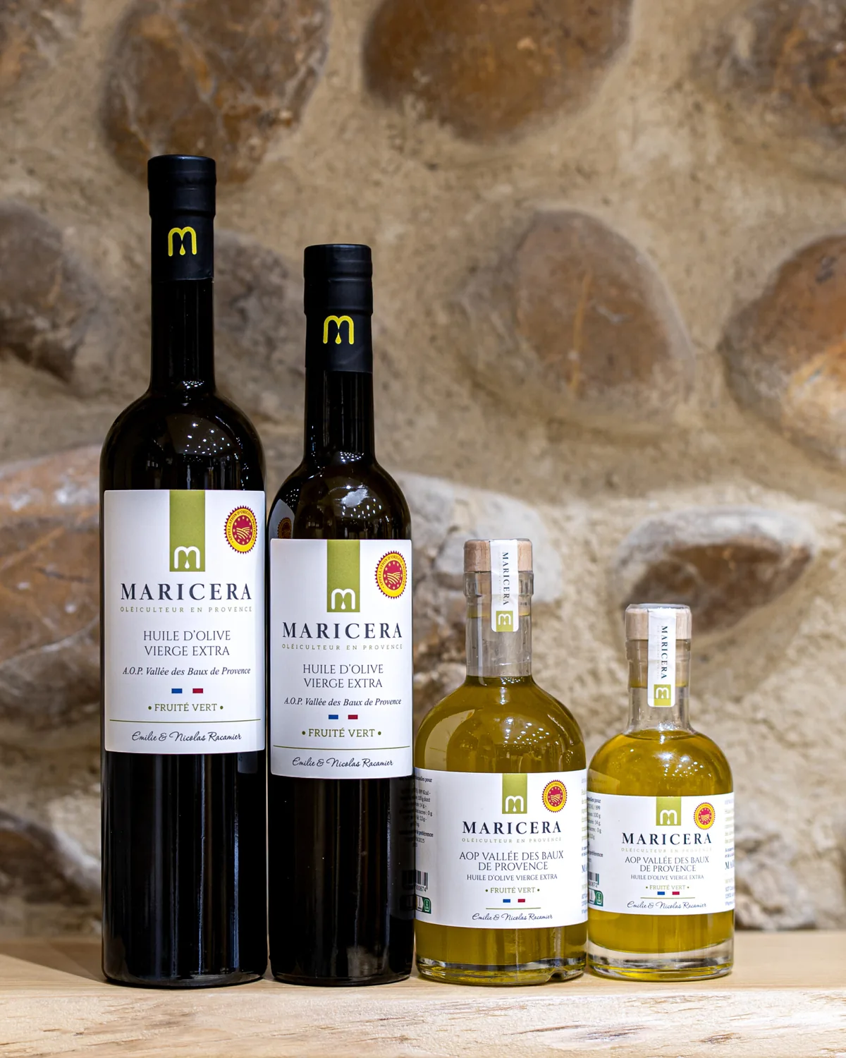 Bouteilles d'huile d'olive Maricera devant un mur de pierres